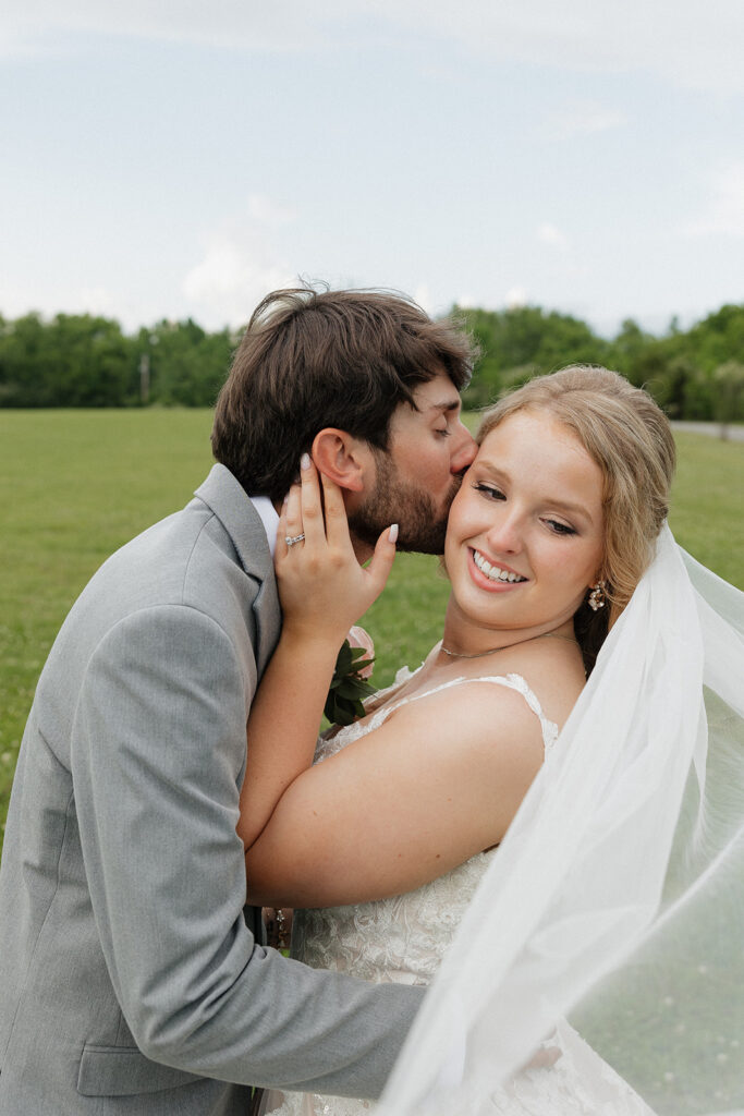 picture of the groom kissing the bride on the cheek