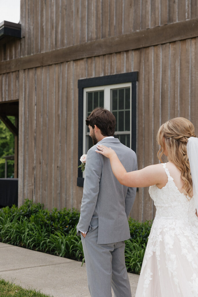 bride touching the grooms shoulder during their first loook