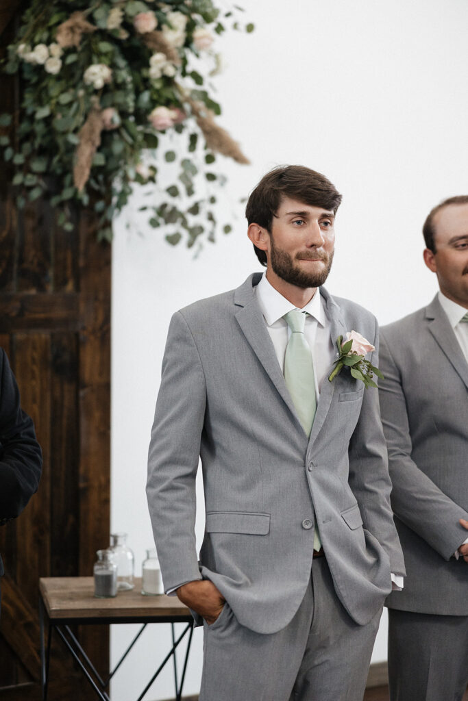 groom watching the bride walk down the aisle 