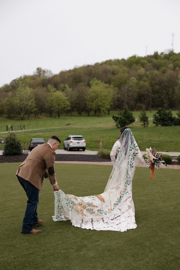 groom helping the bride with her dress