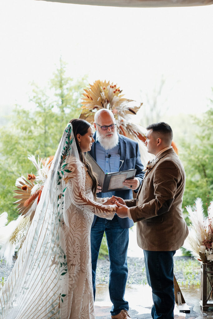 bride and groom holding hands during their wedding ceremony 