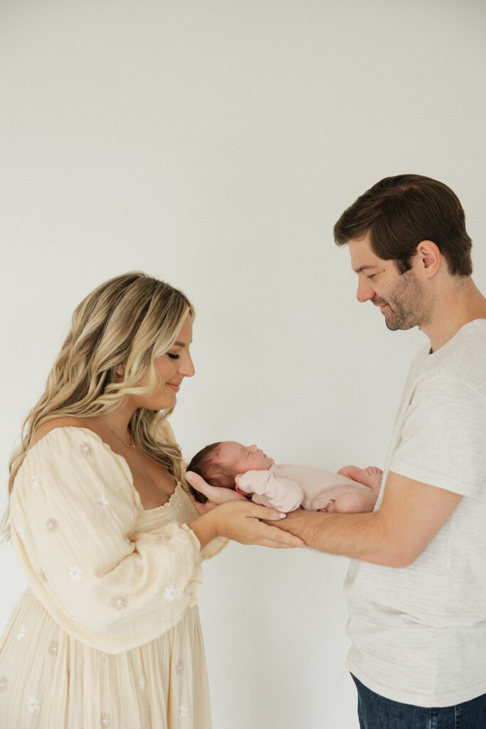 couple looking at their baby at their newborn session