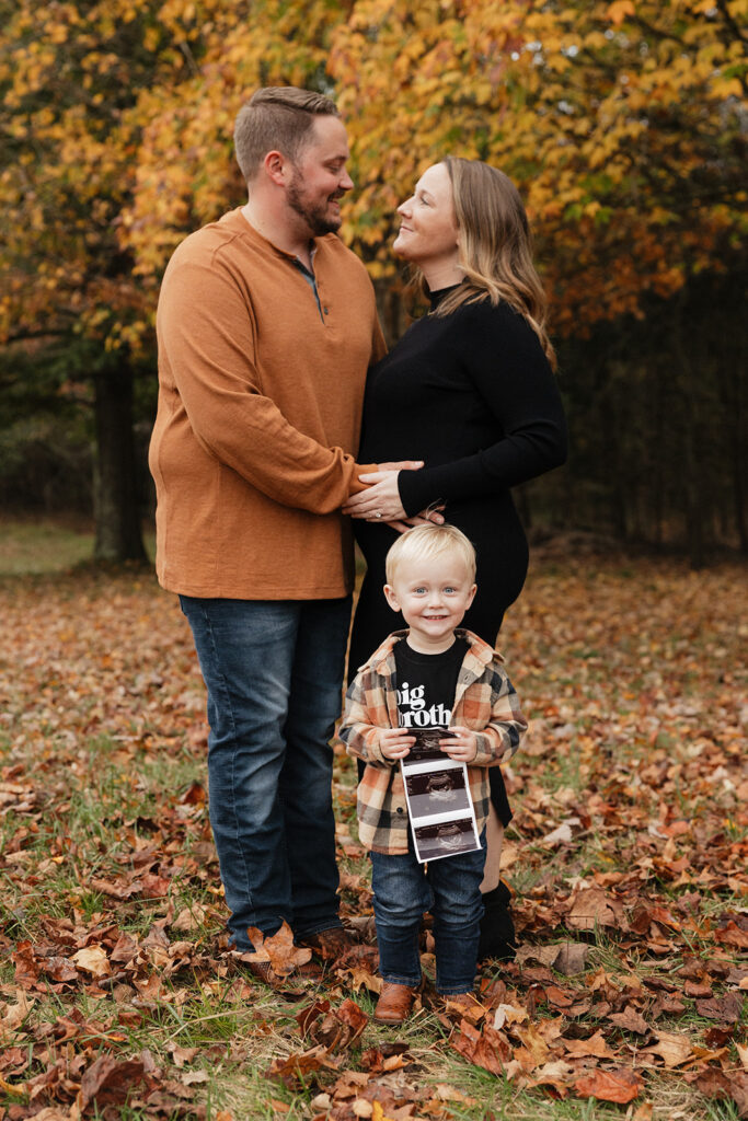 cute couple looking at each other during their fall pregnancy announcement 