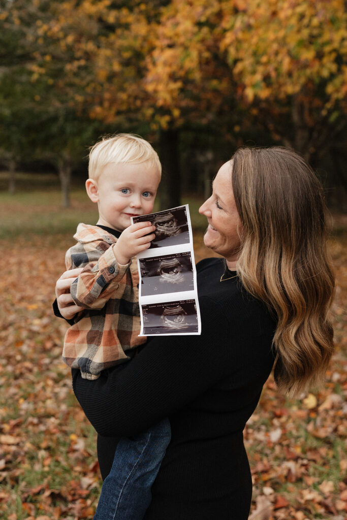 little boy holding his brother sonogram 