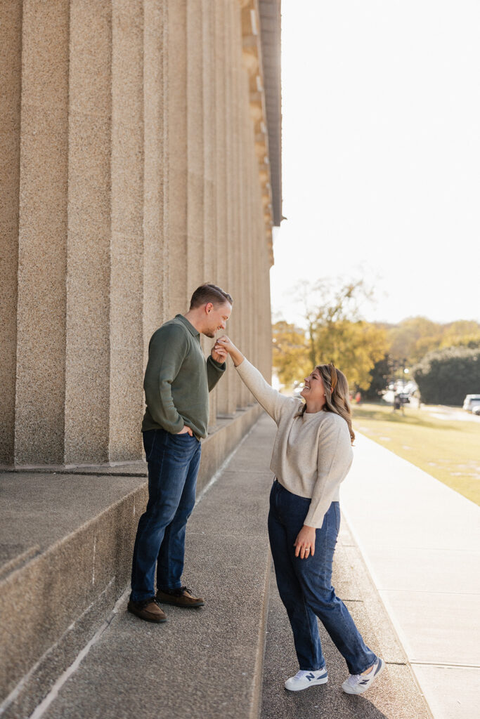 fiance kissing his fiance on the hand during their romantic engagement photoshoot