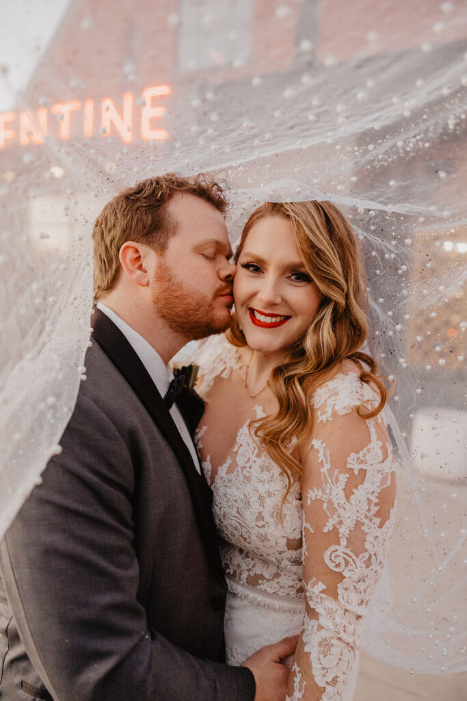 picture of the groom kissing the bride on the cheek