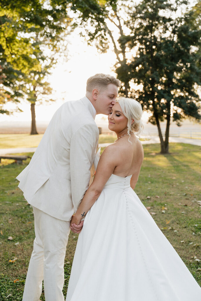 groom kissing the bride on the forehead