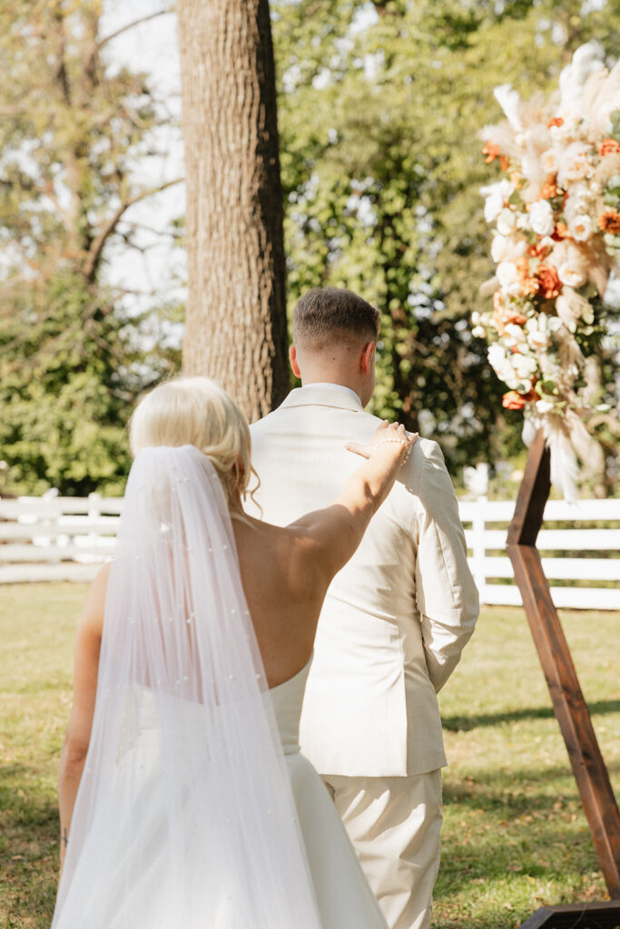 bride and groom at their colorful boho wedding first look before the ceremony