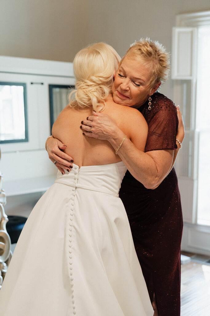 beautiful picture of the bride and her mom hugging before the ceremony