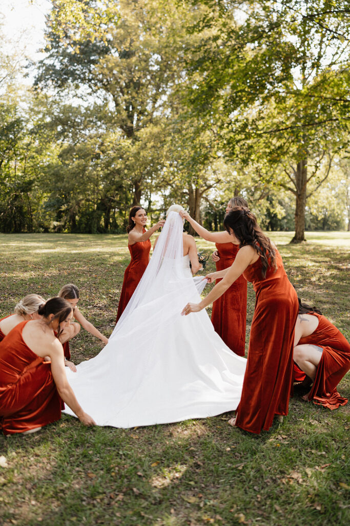 bridesmaids helping the bride with her veil 