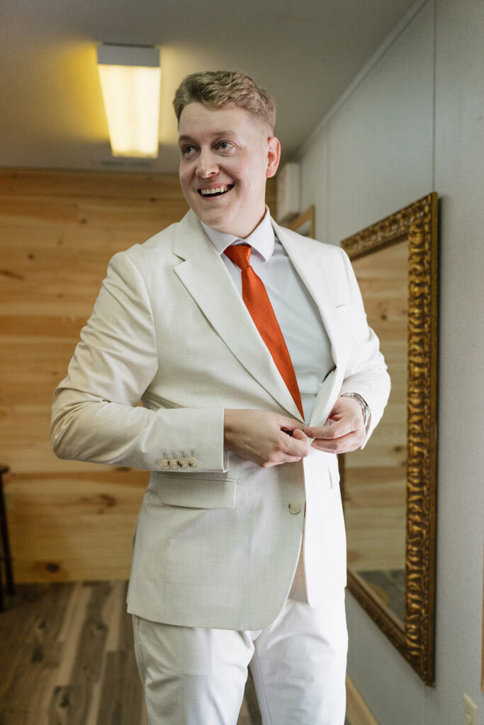 picture of the groom smiling before his first look with the bride