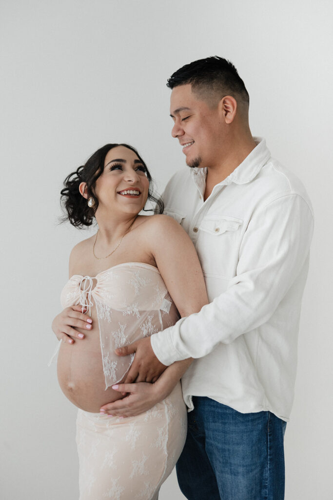 cute couple looking at each other during their studio maternity photoshoot