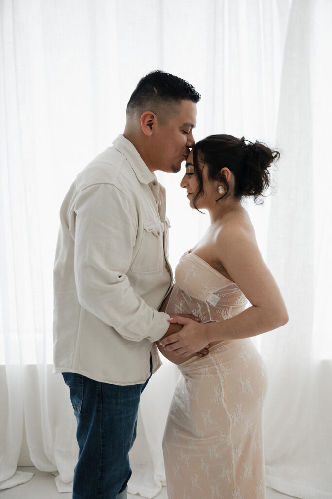 husband kissing his wife on the forehead 