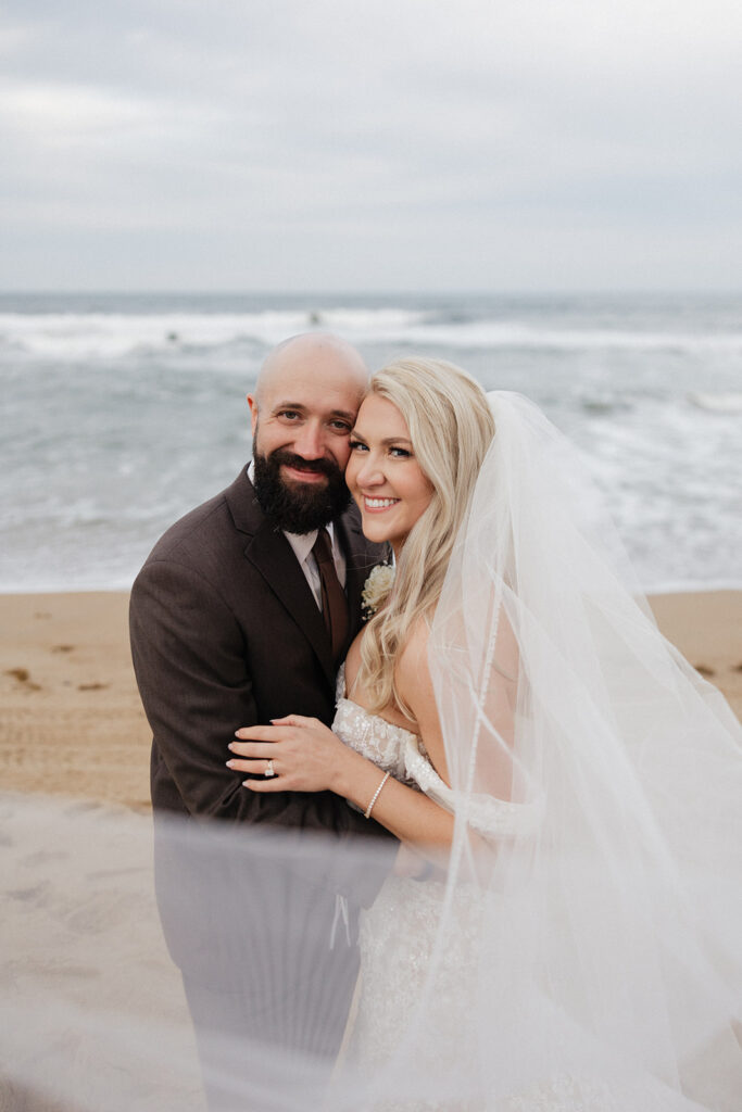 cute couple looking at the camera during their dream beach wedding