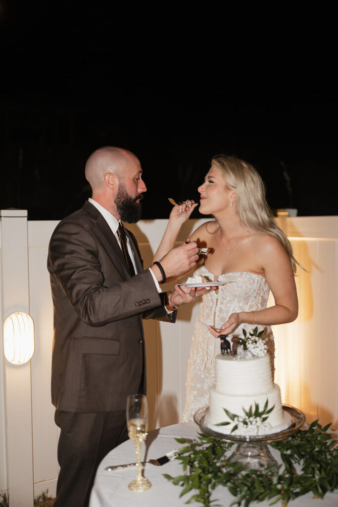 newlyweds trying their wedding cake
