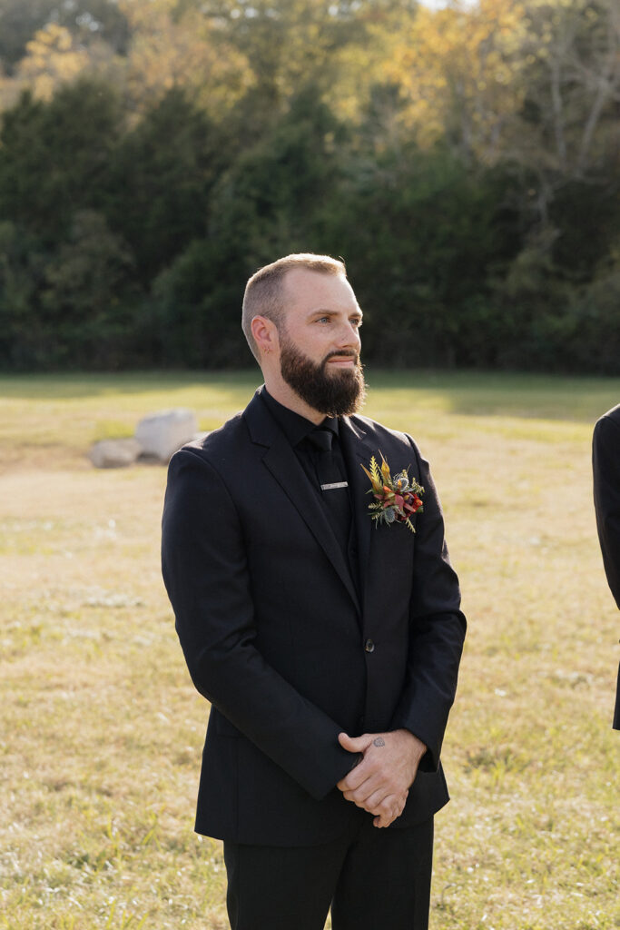 groom watching the bride walk down the aisle