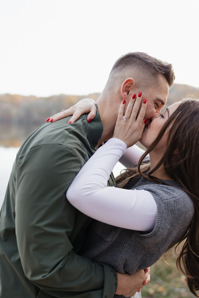 portrait of the newly engaged couple kissing at their proposal
