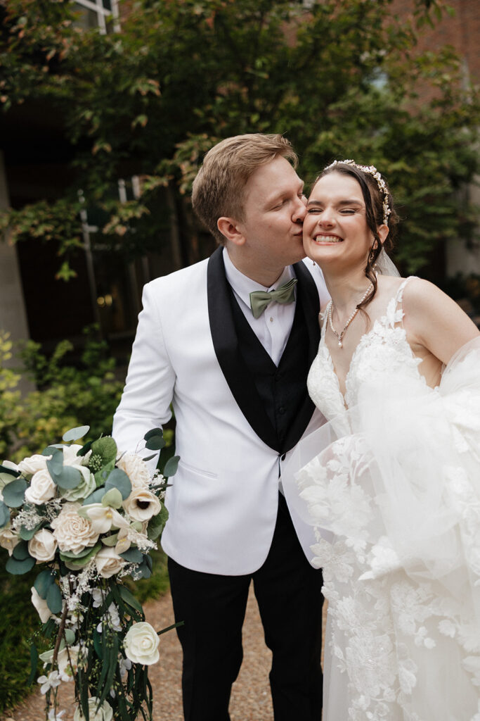cute portrait of the groom kissing the bride on the cheek