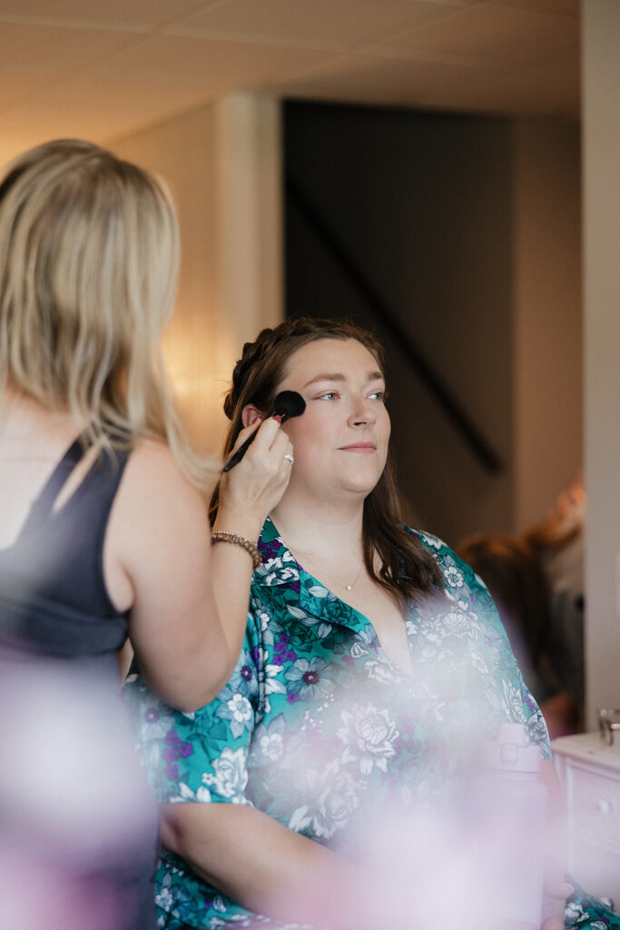 cute picture of the bride getting her hair done during her photoshoot