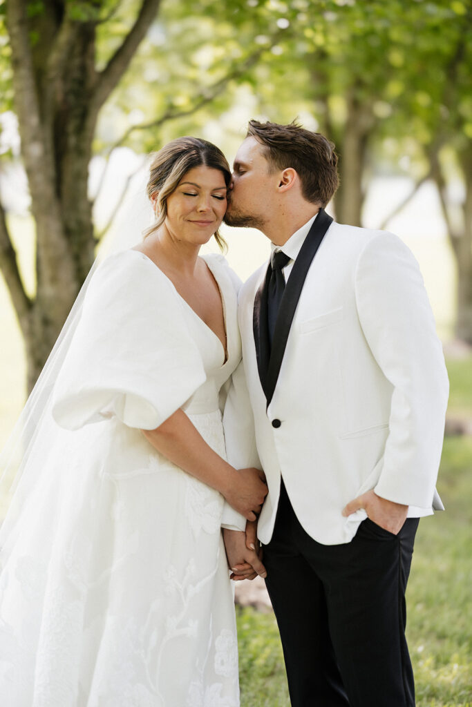 groom kissing the bride on the cheek