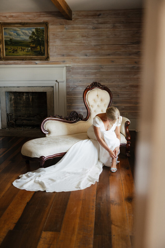 bride putting on her wedding shoes